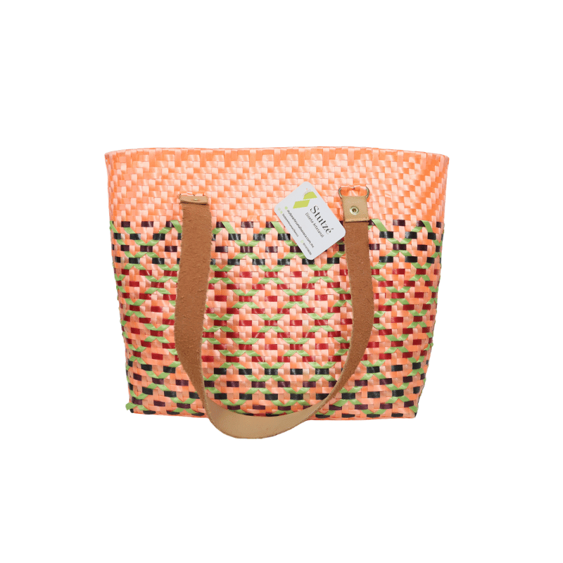 Bolsa artesanal de palma plástica con asa de cuero, tejida a mano por artesanas de Oaxaca con técnicas tradicionales y diseño artesanal mexicano.