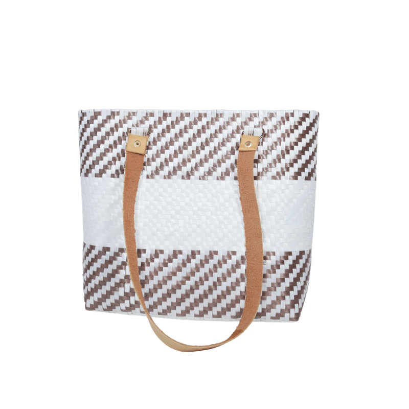 Bolsa artesanal de palma plástica con asa de cuero, tejida a mano por artesanas de Oaxaca con técnicas tradicionales y diseño artesanal mexicano.
