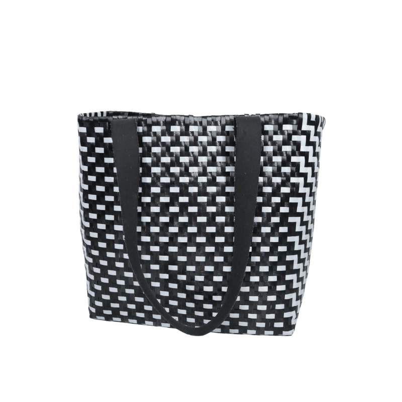 Bolsa artesanal de palma plástica con asa de cuero, tejida a mano por artesanas de Oaxaca con técnicas tradicionales y diseño artesanal mexicano.