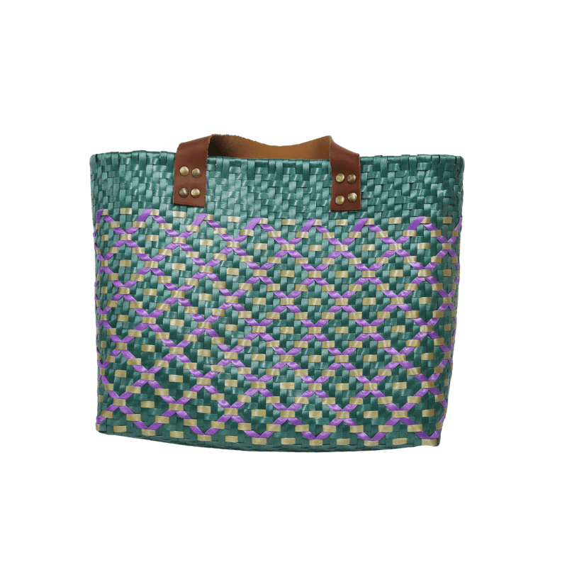 Bolsa artesanal de palma plástica con asa de cuero, tejida a mano por artesanas de Oaxaca con técnicas tradicionales y diseño artesanal mexicano.
