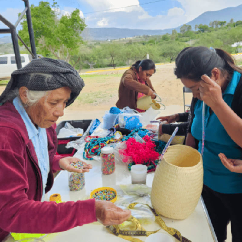 Taller de tejido artesanal de palma en Oaxaca - Stutzé Grupo de artesanas de Oaxaca reunidas en un taller al aire libre trabajando en el tejido artesanal de palma para Stutzé.