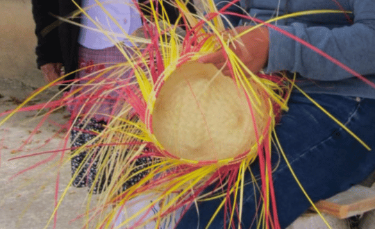 manos tejiendo fibras de palma natural para la elaboración de artesanías en Oaxaca